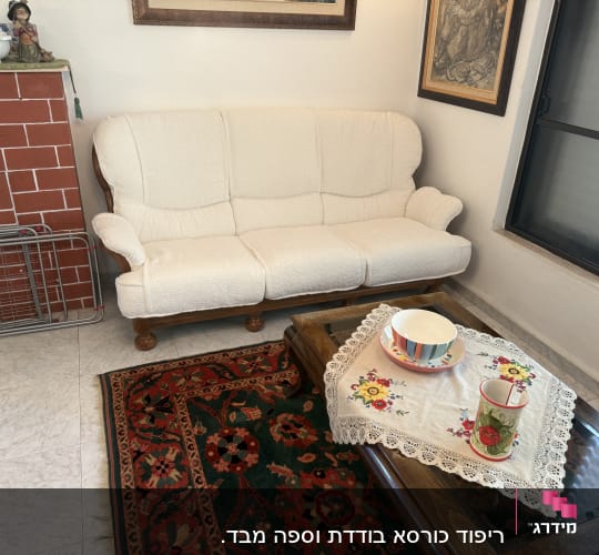סלון עם ספה לבנה ושולחן עץ עם מפה